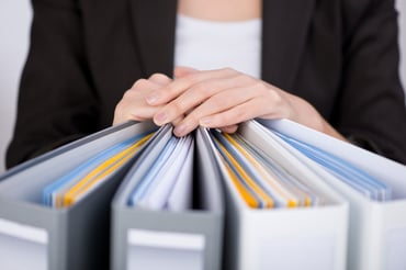 Midsection of businesswoman with binders at office