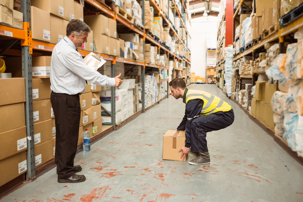 worker in warehouse picking up a box