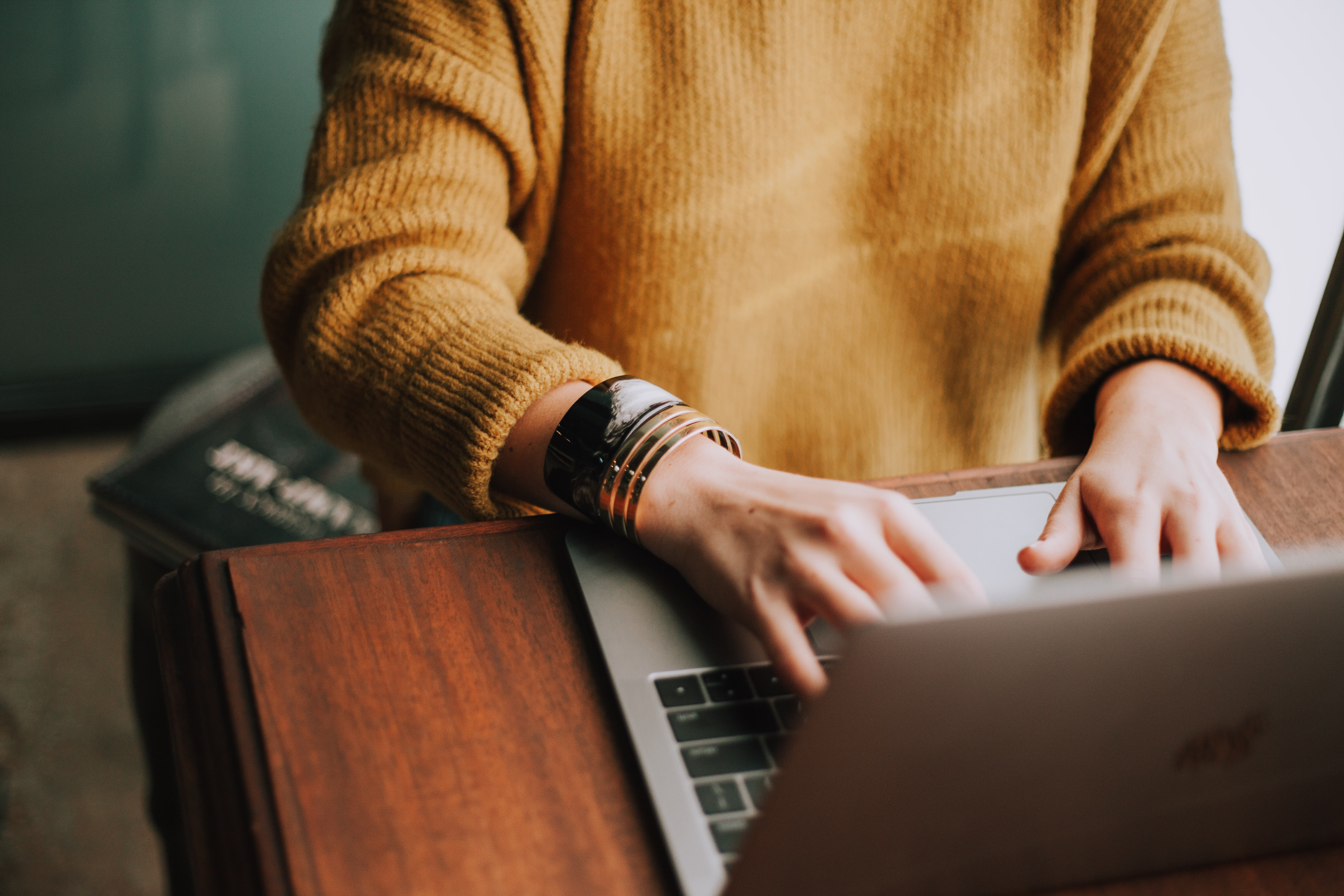 PRT Staffing Resume Tips for Little Job Experience Person in Gold Sweater in Front of Laptop