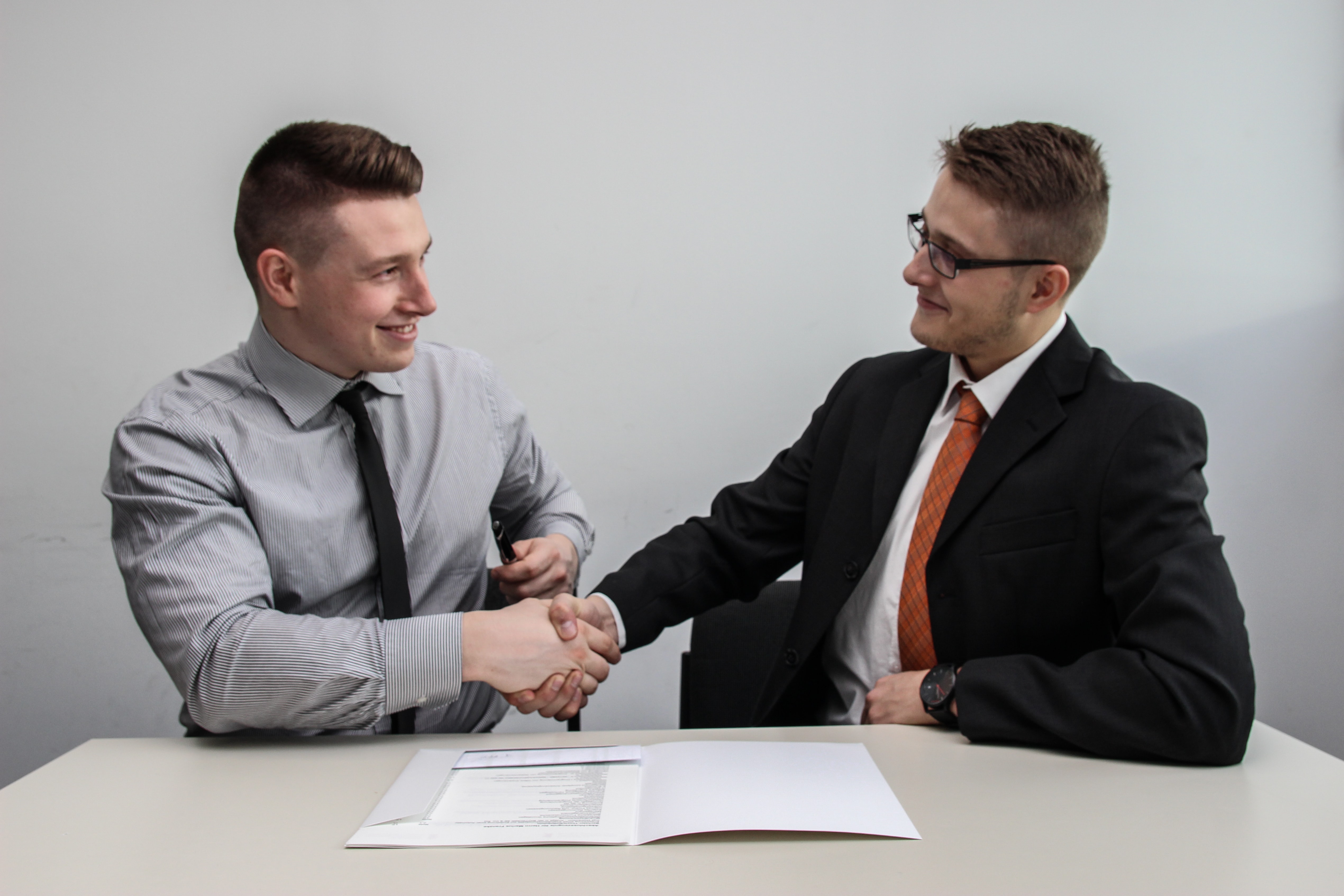 PRT Staffing Hiring Temp Workers a Great Solution to Staffing Shortages Two Professional Men at Table Shaking Hands